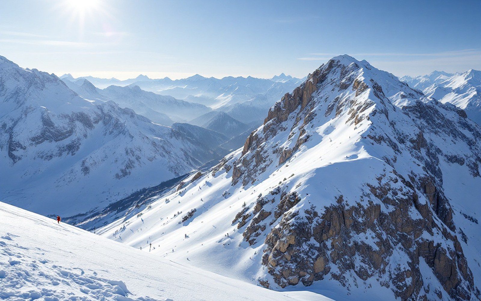 A high snowfield under a wide sky with a distant ridge line